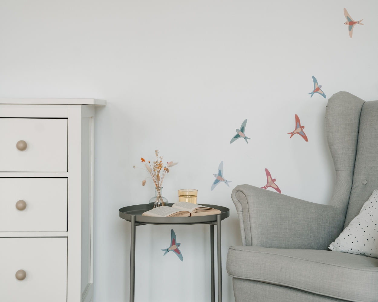 Kuschelecke im Babyzimmer mit Stillsessel und Wanddeko