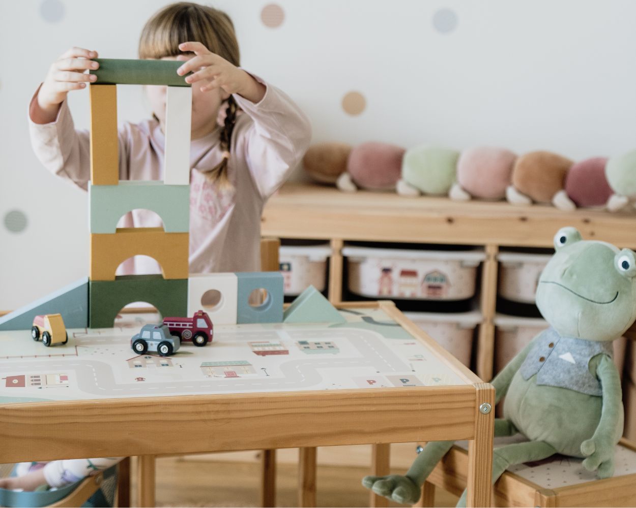 Maedchen spielt mit Bauklötzen am Spieltisch