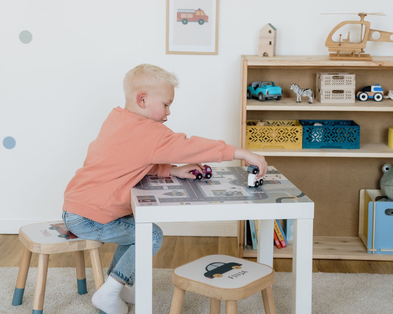 Junge am Spielen mit Autos am Kindertisch